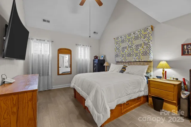 a spacious bedroom with a bed and a flat screen tv