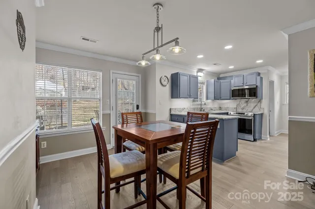 a view of a dining room and livingroom with furniture window and wooden floor