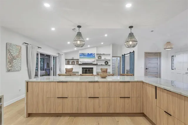 a bedroom with a bed couch chandelier and a window