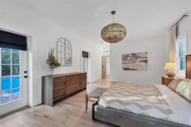 a bedroom with a bed a dresser and flat screen tv