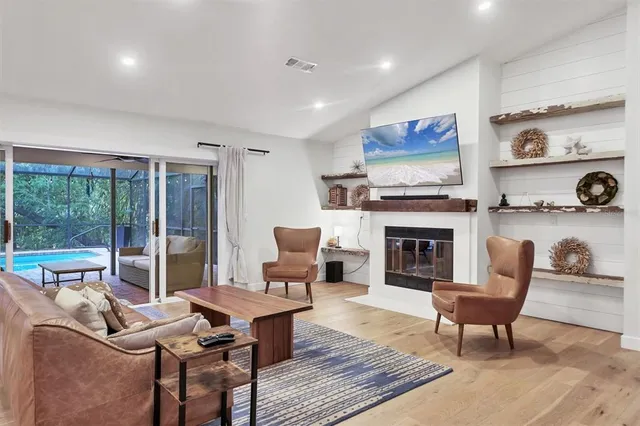 a living room with furniture a fireplace and a flat screen tv