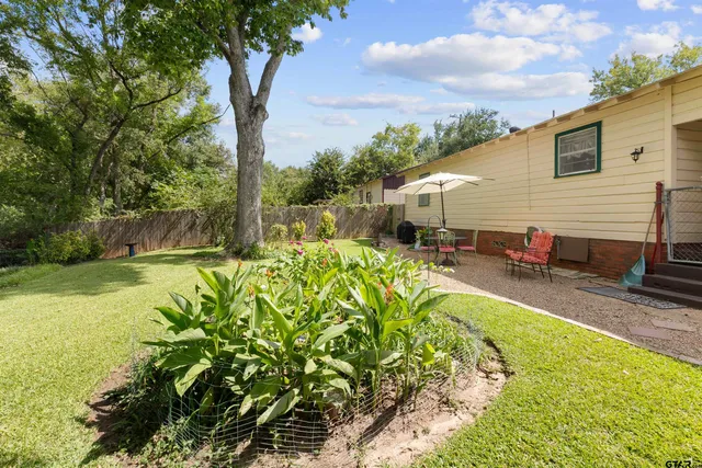 a backyard of a house with table and chairs