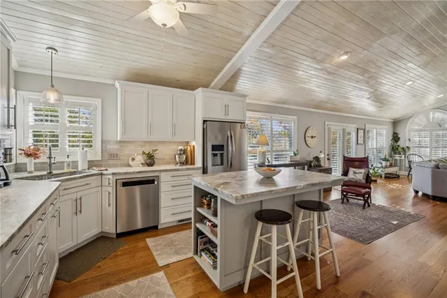 a kitchen with stainless steel appliances kitchen island granite countertop a stove a sink and a microwave