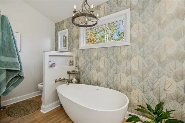 a bathroom with a granite countertop sink a toilet and shower