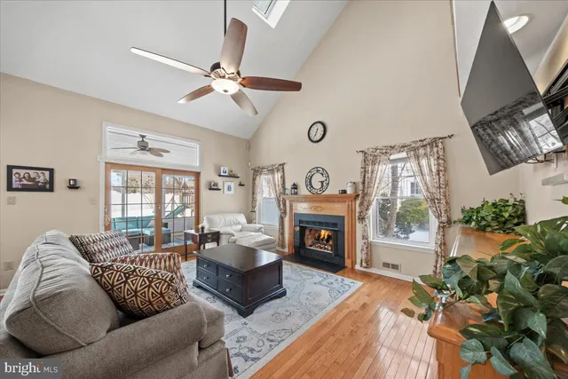 a view of a dining room and livingroom with furniture wooden floor kitchen view and a chandelier