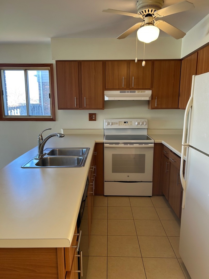 626 Terry Court, Unit A Roselle, IL 60172 - Photo 3 of 15 a kitchen with a stove sink and a refrigerator