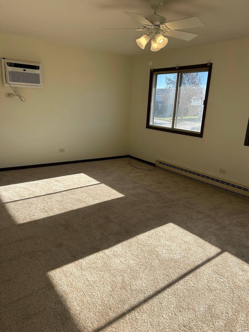 626 Terry Court, Unit A Roselle, IL 60172 - Photo 8 of 15 a view of a livingroom with wooden floor and a ceiling fan