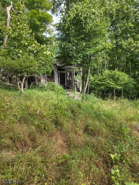 13 Stonehenge Road Lake Hopatcong, NJ 07849 - Photo 10 of 12 a backyard of a house with lots of green space and fountain