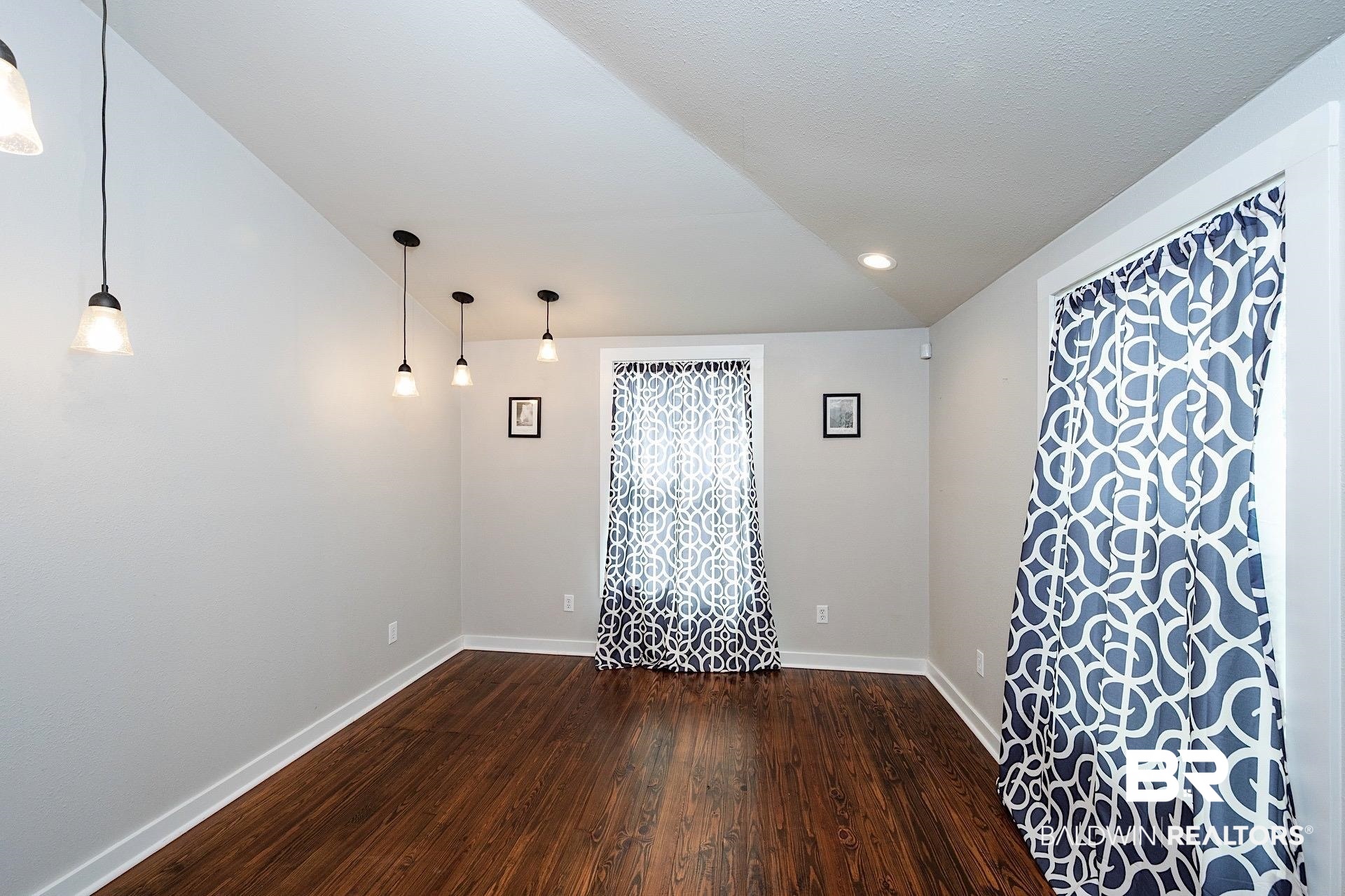 22051 Broad Street Silverhill, AL 36576 - Photo 10 of 28 Unfurnished room featuring dark hardwood / wood-style floors and lofted ceiling