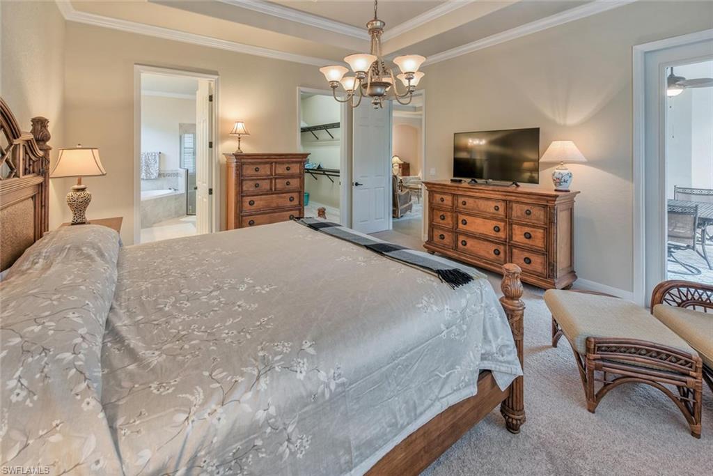 9387 Vercelli Court Naples, FL 34113 - Photo 10 of 25 a bedroom with a bed and furniture flat screen tv