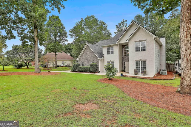 a view of a house with backyard and sitting area