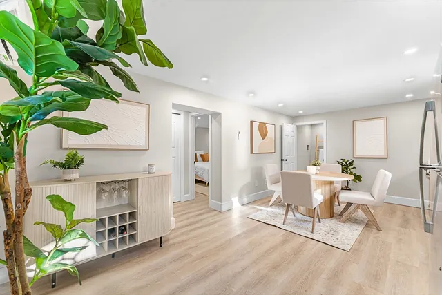 a living room with furniture a fireplace a potted plant and a wooden floor
