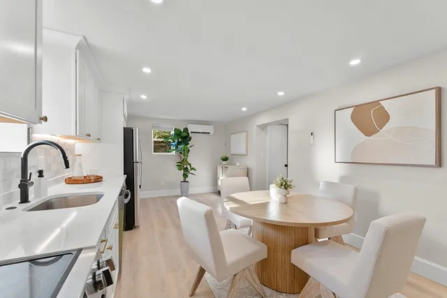 a kitchen with stainless steel appliances a table and chairs