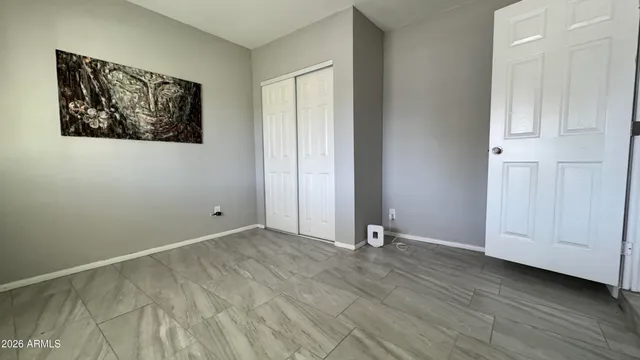 an empty room with wooden floor and window