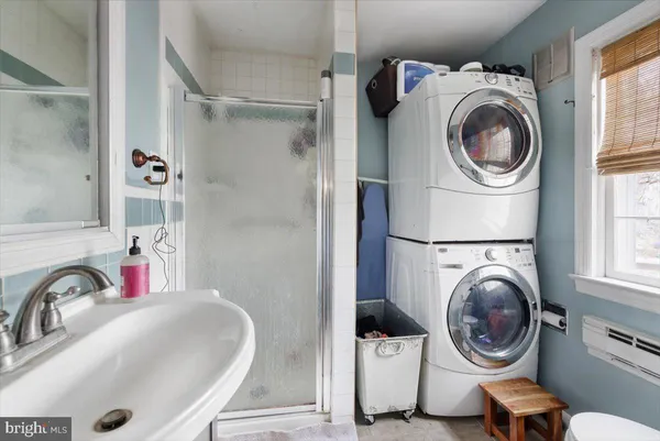 a bathroom with a granite countertop sink a toilet a mirror and shower