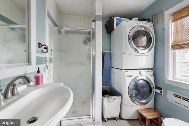 a bathroom with a granite countertop sink a toilet a mirror and shower