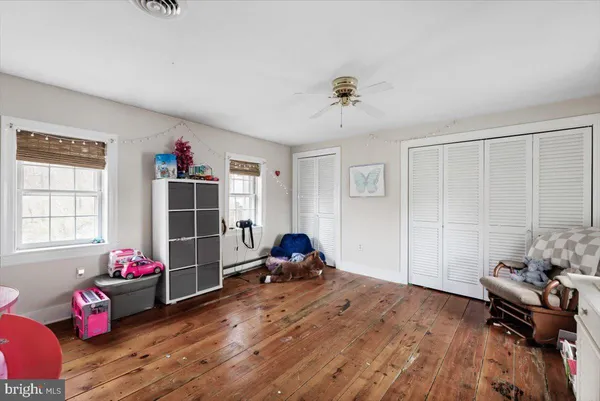 a living room with a bed furniture flat screen tv and a large window