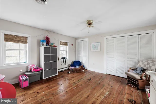 a living room with a bed furniture flat screen tv and a large window
