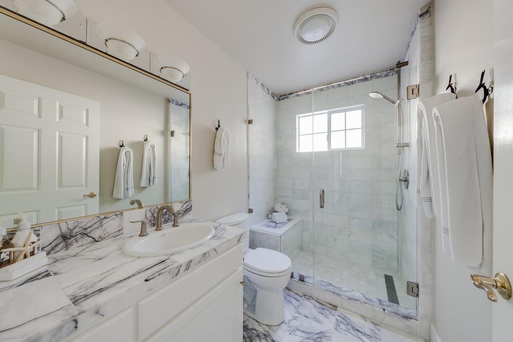 25220 Quail Ridge Road Los Gatos, CA 95033 - Photo 49 of 94 a bathroom with a granite countertop sink toilet a shower and a mirror