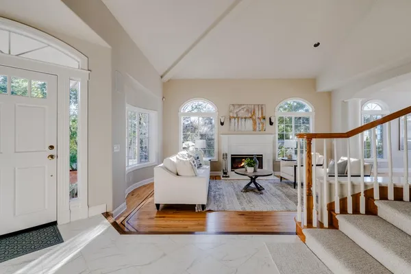 a living room with furniture a fireplace and a chandelier
