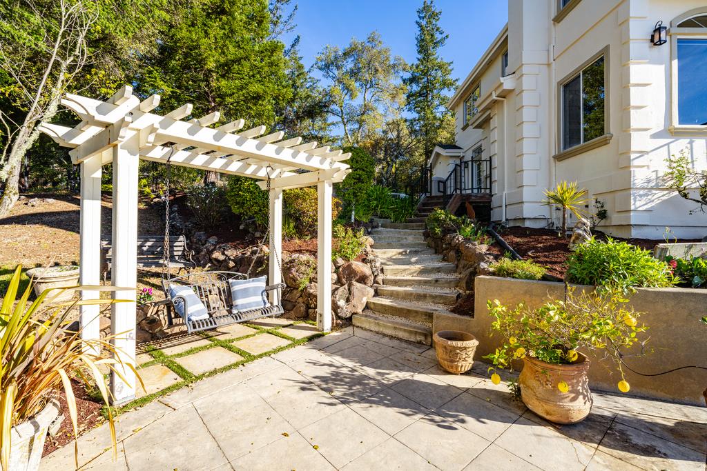 25220 Quail Ridge Road Los Gatos, CA 95033 - Photo 88 of 94 a view of a patio with table and chairs potted plants and large tree