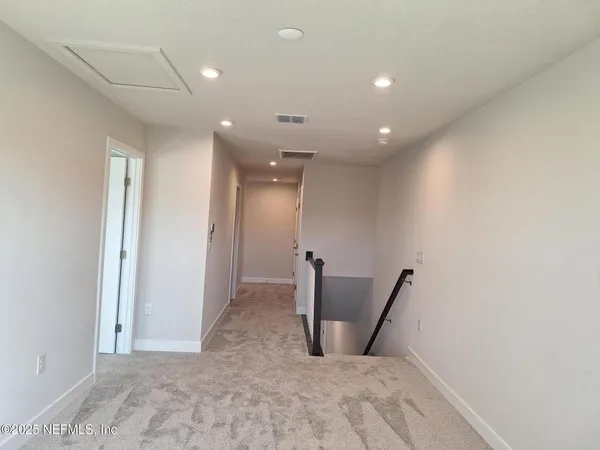 a view of a hallway with wooden floor and a window