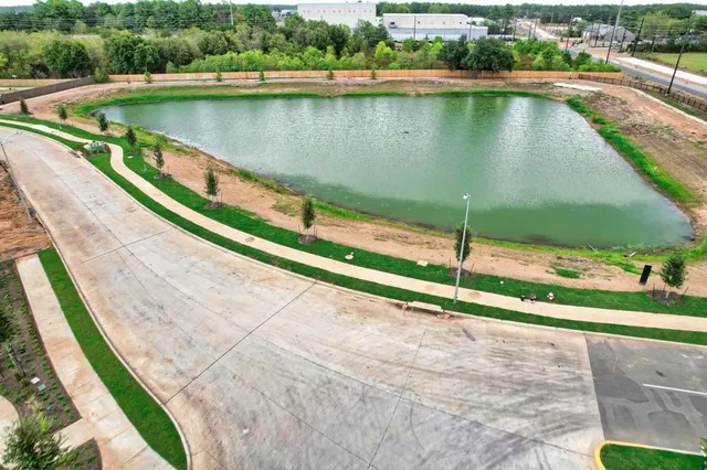 a view of a lake with a yard and large trees