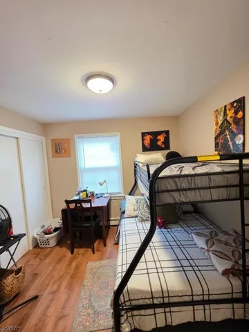 a bedroom with a bed and wooden floor