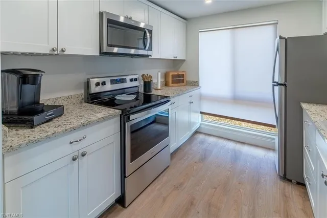 a kitchen with granite countertop a sink stove and refrigerator