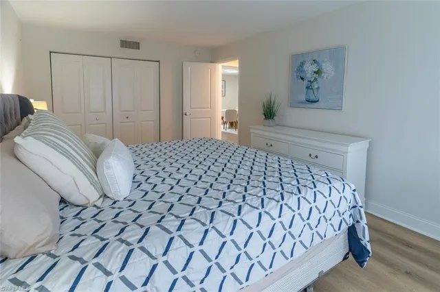 a bedroom with a bed and painting on the wall