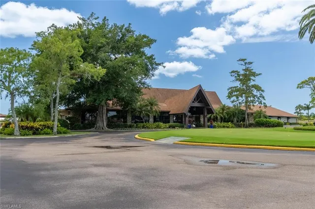 a view of a house with a big yard and a large trees