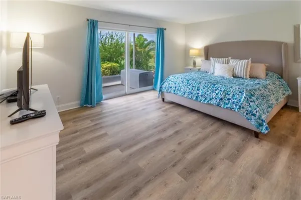 a bedroom with a bed wooden floor and window