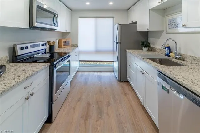 a kitchen with kitchen island granite countertop a sink stove and refrigerator