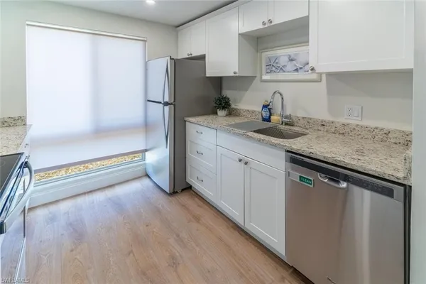a kitchen with stainless steel appliances granite countertop a refrigerator and a sink