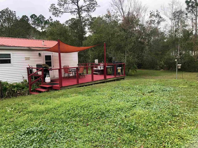 a backyard of a house with table and chairs