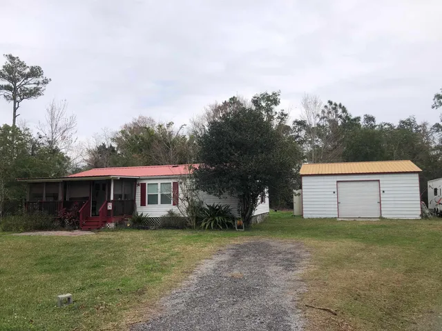 a view of a house with a yard and sitting area