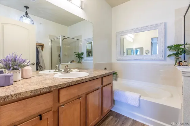 a bathroom with a granite countertop sink mirror and a bathtub