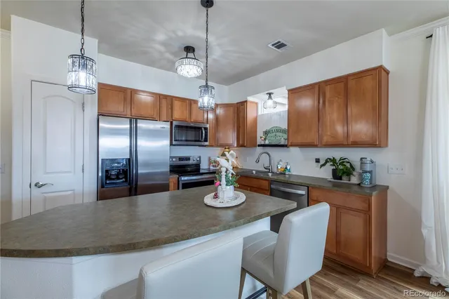 a large kitchen with kitchen island a island a sink a stove and wooden floor