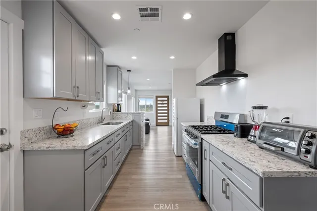 a kitchen with stainless steel appliances granite countertop a sink stove and refrigerator