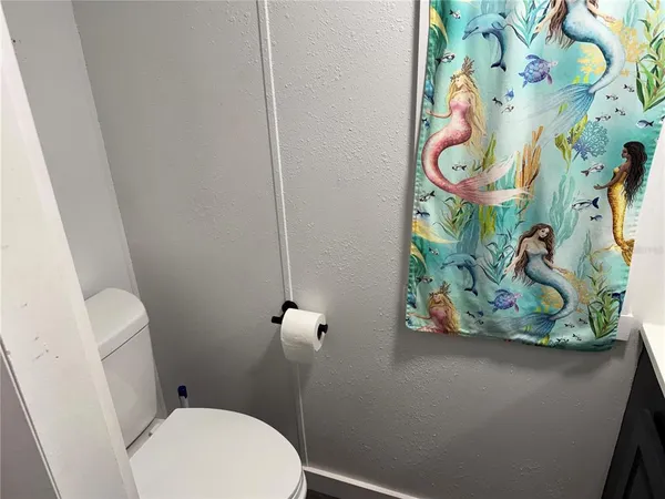 a white toilet sitting next to a shower curtain