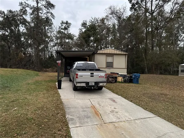 a view of a car parked in back yard of a house