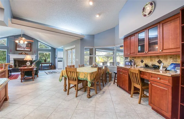 a dining hall with stainless steel appliances granite countertop a table and chairs
