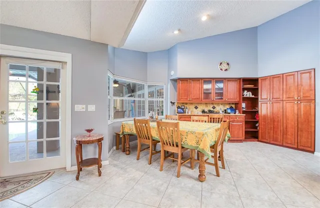 a dining room with furniture and a floor to ceiling window