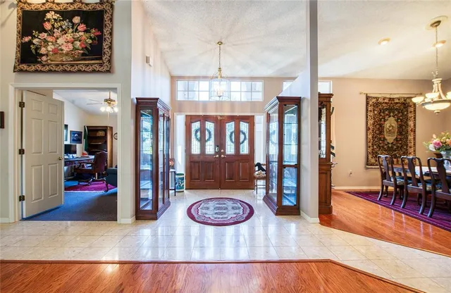 a view of a hallway with furniture and a chandelier