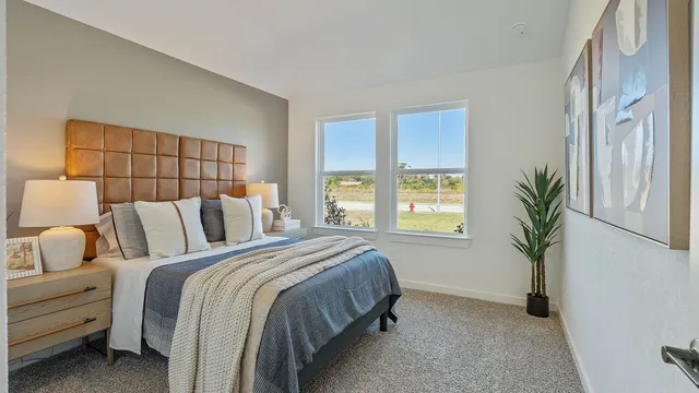 a bed sitting in a bedroom next to a window