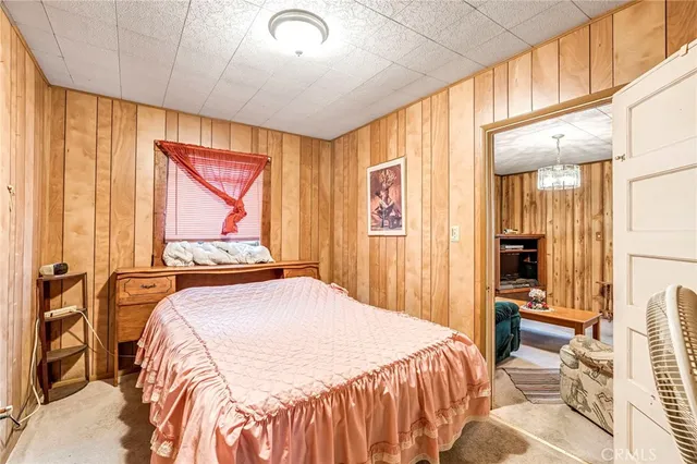 a bedroom with a bed and a large mirror next to a window
