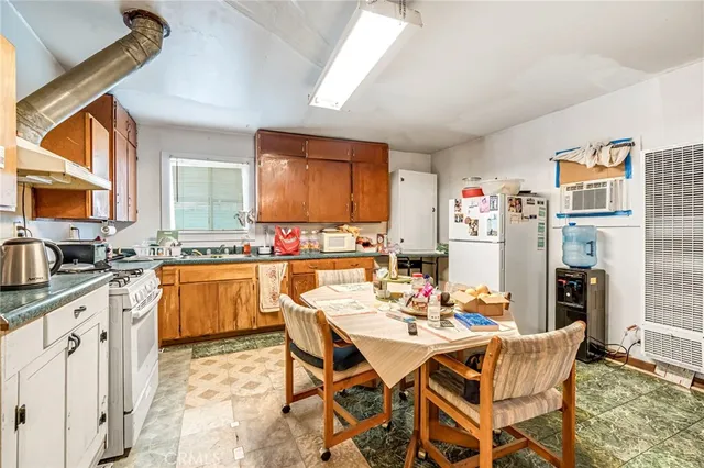 a dining room with stainless steel appliances kitchen island granite countertop a dining table and chairs