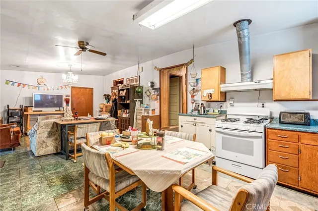 a kitchen with a stove a table and chairs in it