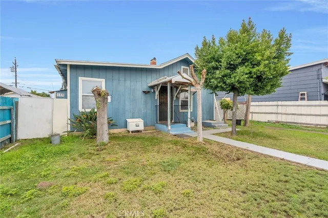 a view of a house with backyard and a tree