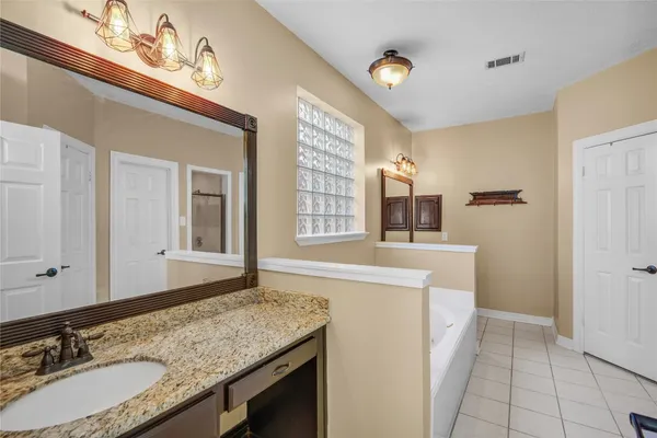 a bathroom with a granite countertop sink a mirror and a shower